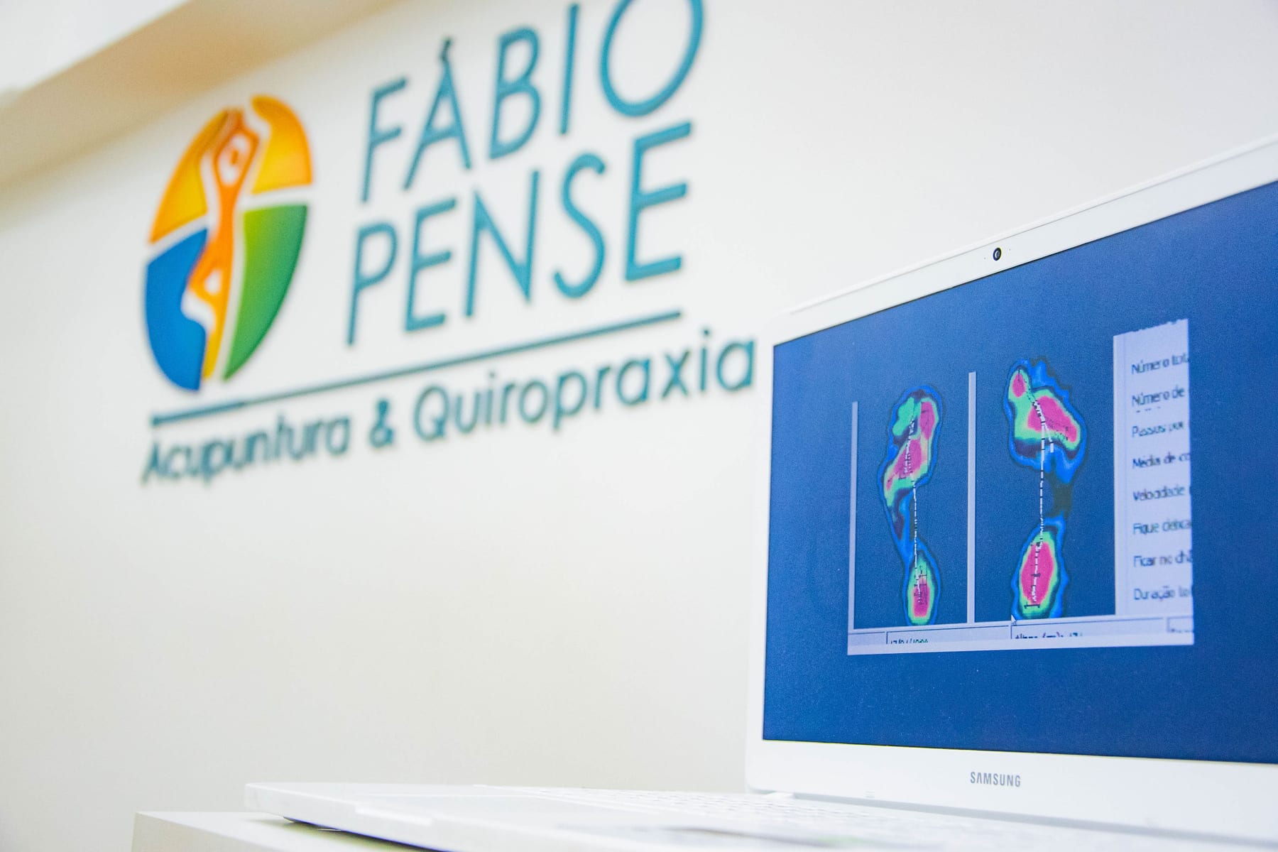 Paciente realizando baropodometria computadorizada sobre plataforma de sensores na Clínica Fábio Pense, em Lourdes, Belo Horizonte